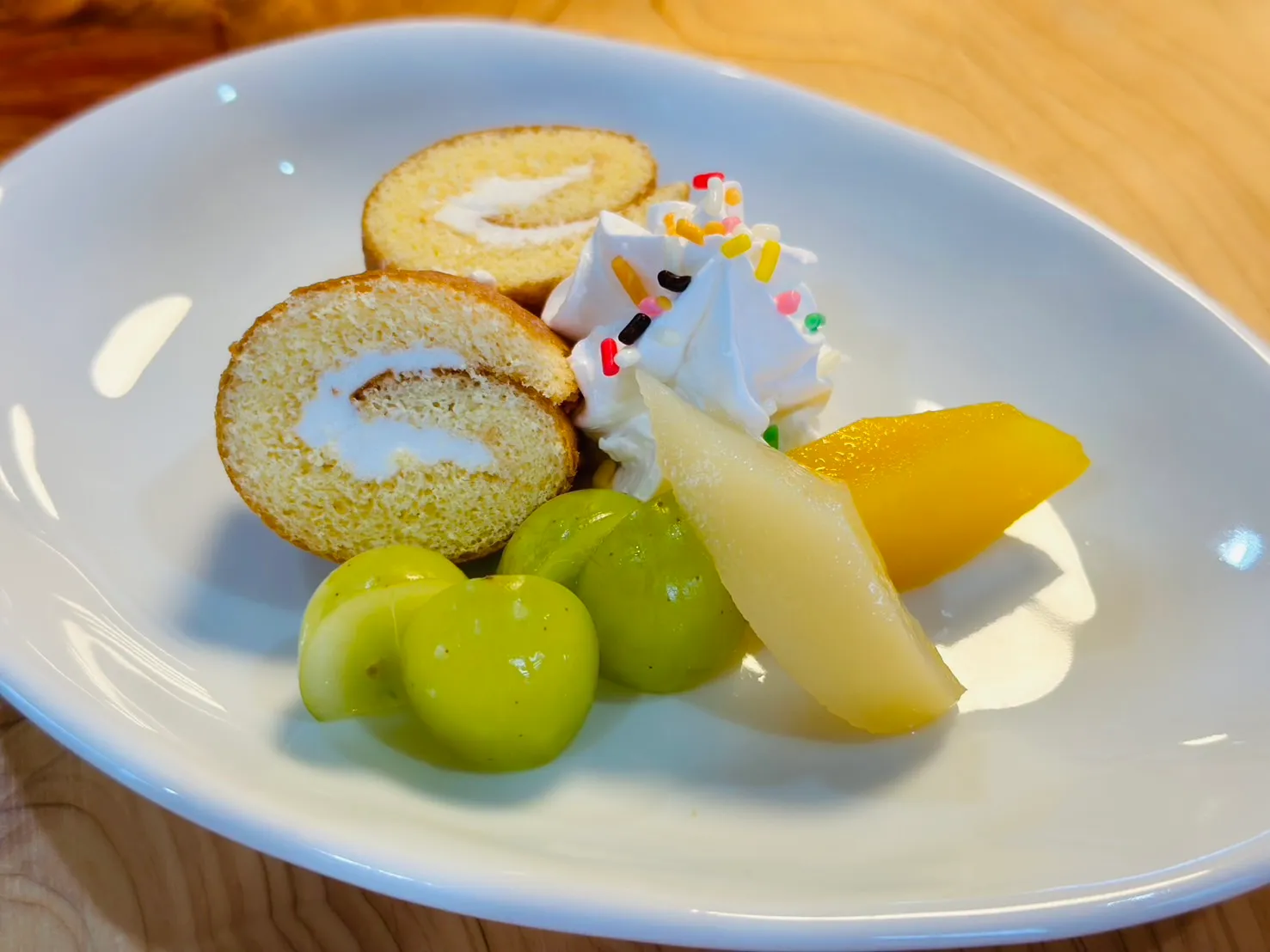 ロールケーキと果物を盛り付けた季節のおやつ
